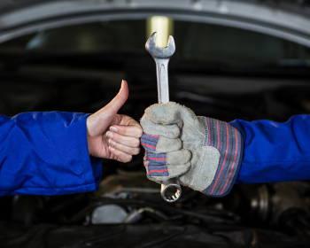Mechanics holding spanner and showing thumbs up