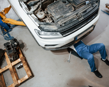 Artificial lighting. Employee in the blue colored uniform works in the automobile salon